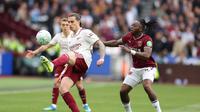 Pemain Arsenal, Riccardo Calafiori, menerima bola di depan pemain West Ham United, Aaron Wan-Bissaka, dalam pertandingan Liga Inggris di London Stadium, Inggris, Minggu (10/5/2026) malam WIB. (AP Photo/Ian Walton)