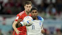 Pemain Inggris, Marcus Rashford (kanan) berebut bola dengan pemain Wales, Ben Davies saat matchday ketiga Grup B Piala Dunia 2022 di Ahmad Bin Ali Stadium, Rabu (30/11/2022). (AP/Abbie Parr)