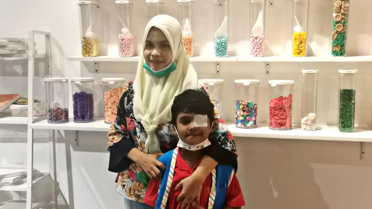 Anak pengidap kanker mata (6) dan sang Ibu, Desi (27) di acara 'Roche Children's Walk' bersama Roche Indonesia dan Yayasan Kasih Anak Kanker Indonesia (YKAKI), Selasa, (27/5/2023).