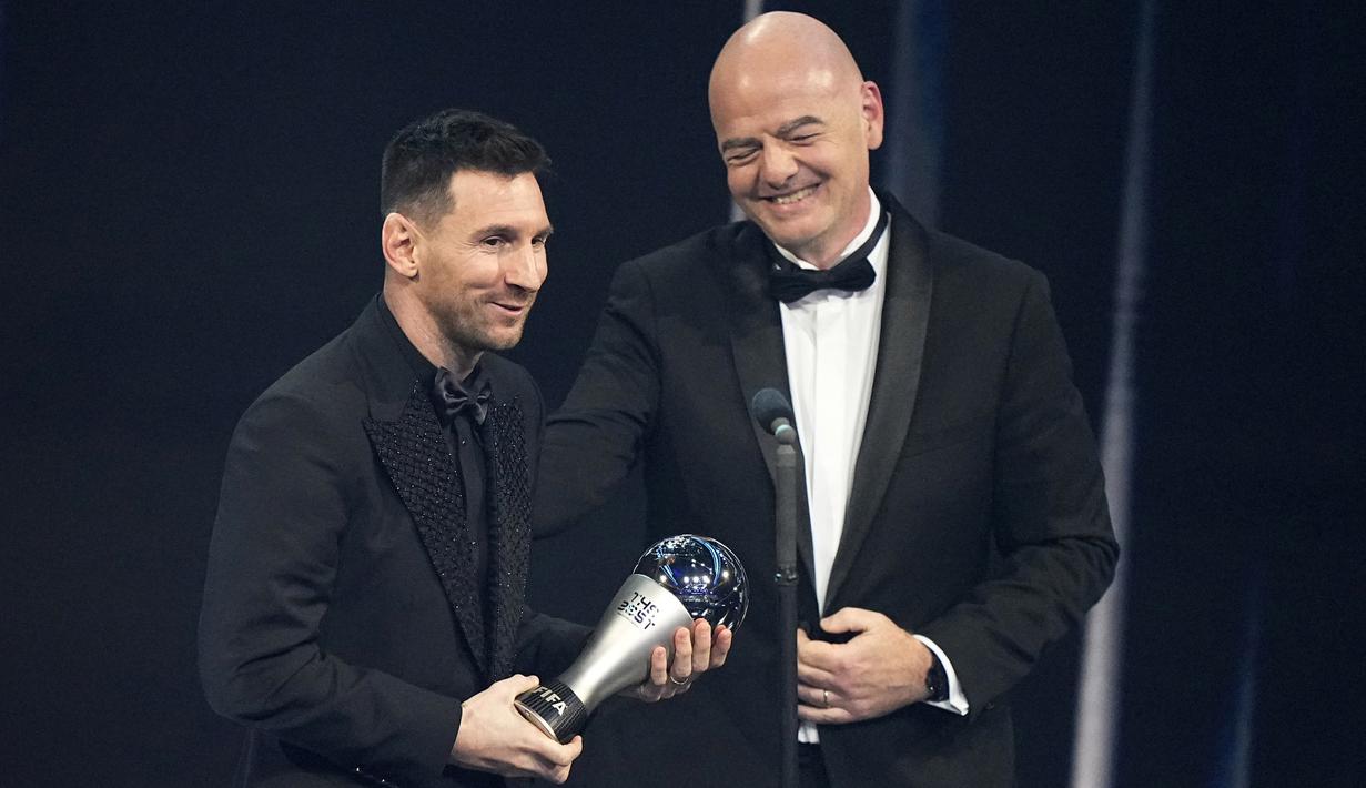 Presiden FIFA, Gianni Infantino, memberikan trofi penghargaan kepada Lionel Messi sebagai pemain terbaik FIFA 2022 di Paris, Selasa (28/2/2023). (AP Photo/Michel Euler)