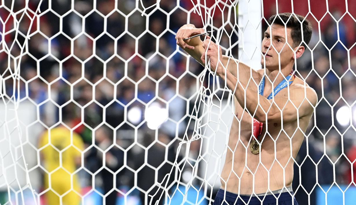 Matteo Pessina memotong jaring gawang Italia tanpa mengenakan bajunya. Berkalungkan medali juara, Ia tampak menikmati setiap potongannya. (Foto: AP/Pool/Paul Ellis)