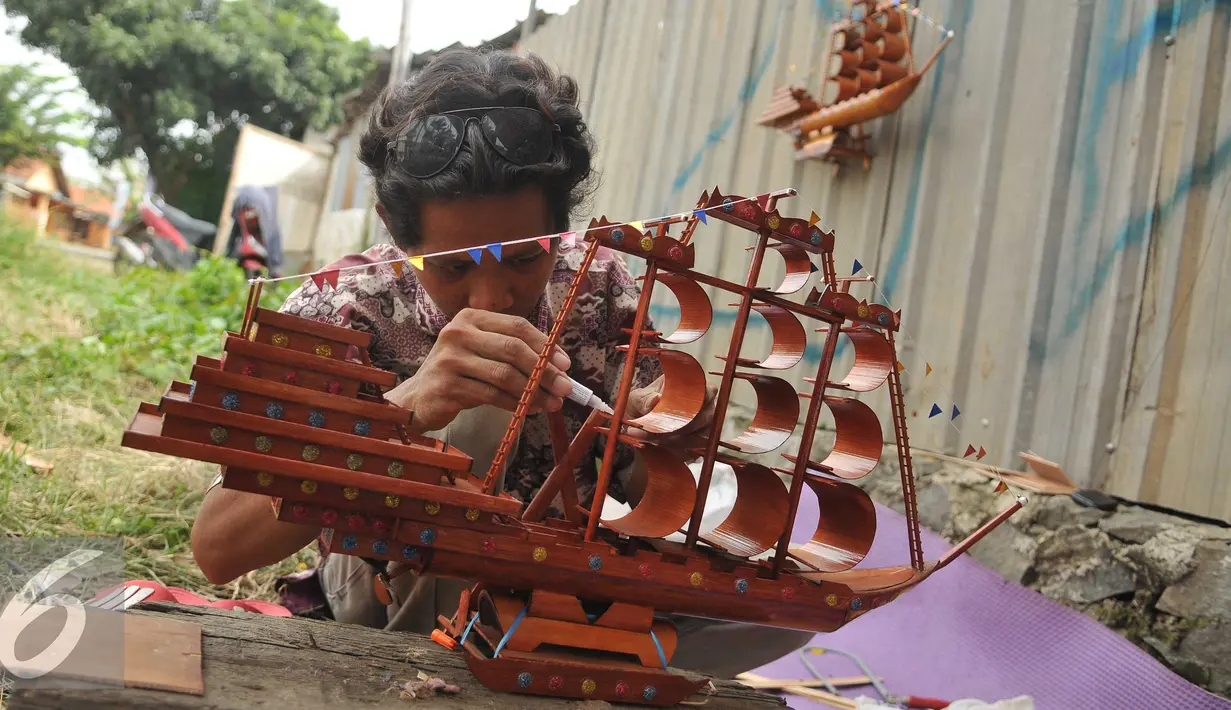 Perajin merekatkan miniatur perahu phinisi yang terbuat dari bambu, Jawa Barat, Sabtu (9/7). Perajin mengaku membanjirnya produk kerajinan dari China menyebabkan terhentinya ekspor dan penurunan permintaan dalam negeri. (Liputan6.com/Gempur M Surya)