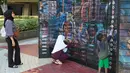 Pengunjung mengamati karya dalam pameran seni rupa kontemporer luar ruang Jakarta Provoke! di Taman Menteng, Jakarta Pusat, Jumat (17/7/2026). Pameran gratis yang berlangsung hingga 26 Juli 2026 ini menghadirkan 25 karya dari 25 seniman dan kolektif tentang dinamika kehidupan Jakarta. (KLY/Budy Santoso)