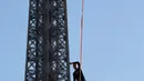 Nathan Paulin menyeimbangkan kaki di seutas tali saat menyeberang dari Menara Eiffel menuju alun-alun Trocadero, Paris, 9 Desember 2017. Aksi itu bagian dari Telethon ke-31 untuk menggalang dana kegiatan penelitian penyakit langka. (JACQUES DEMARTHON/AFP)