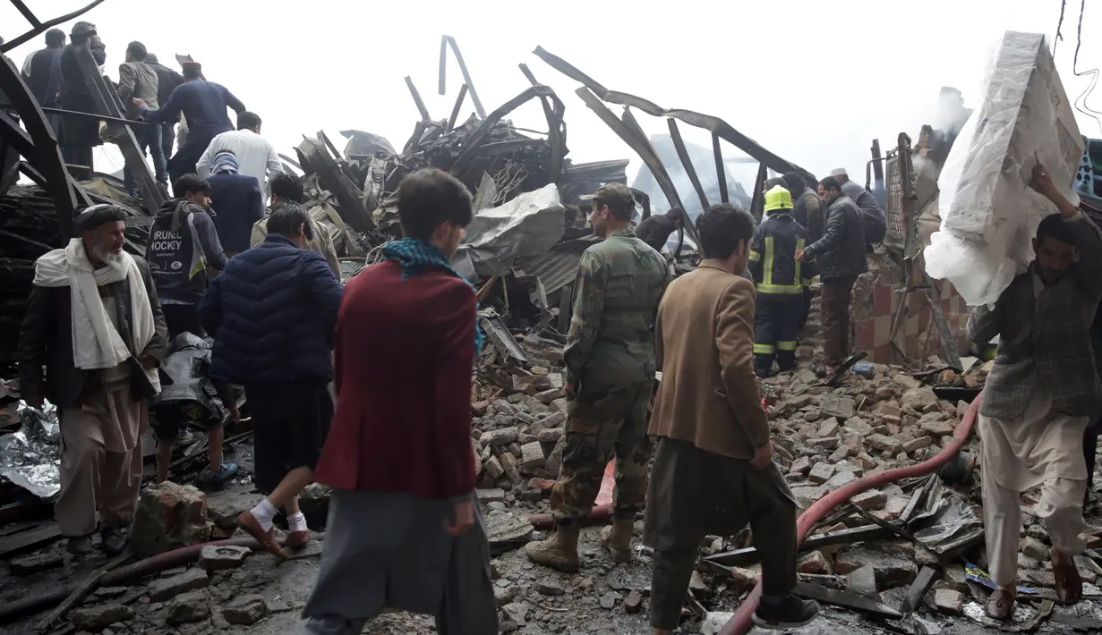 Pemilik toko mencari barang yang tersisa setelah kebakaran di pasar peralatan elektronik di Kabul, Afghanistan (2/11). Warga ibukota Afghanistan bergulat memadamkan kobaran api besar yang menghancurkan ratusan toko. (AP Photo/Massoud Hossaini)