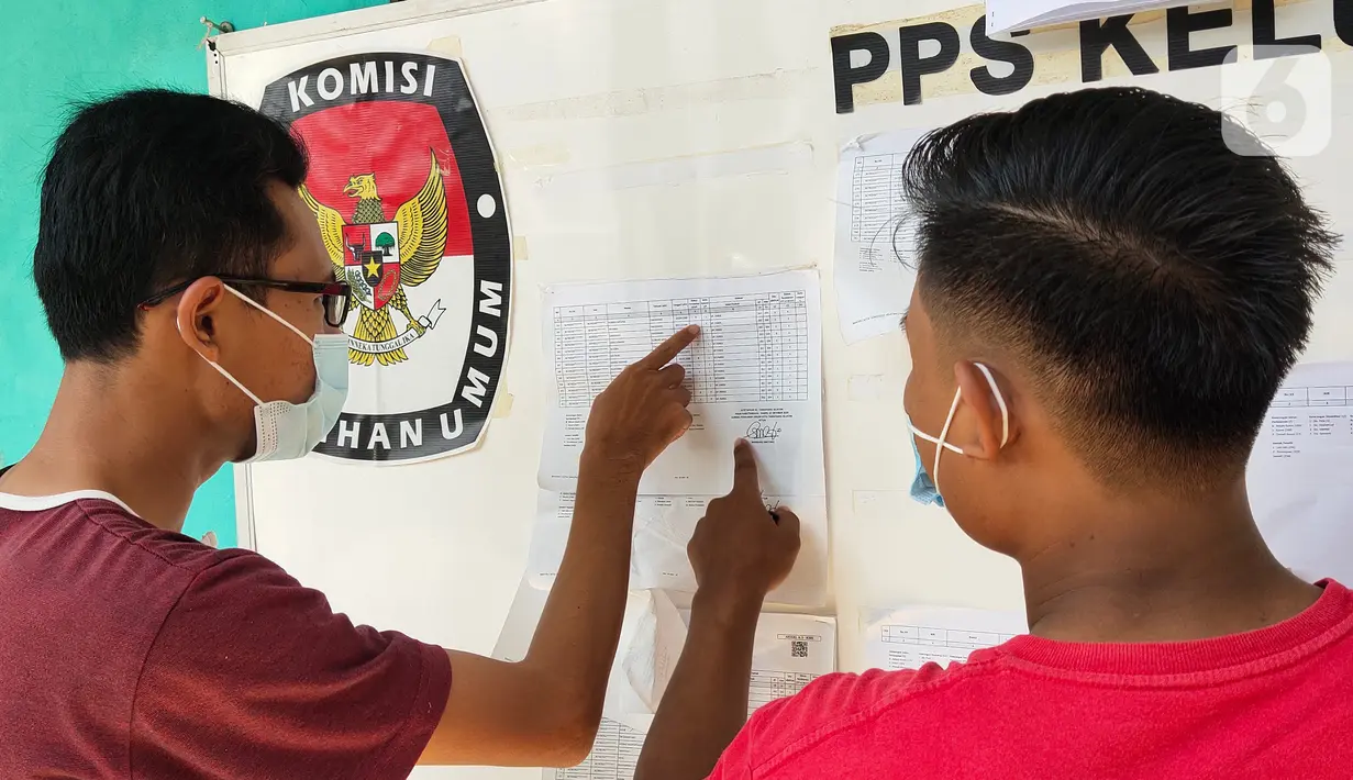 Warga mengecek Daftar Pemilih Tetap (DPT) di kelurahan Parigi, Tangerang, Selasa (8/12/2020). Pengecekan untuk memastikan agar warga dapat mengikuti pemilihan kepala daerah yang akan berlangsung besok. (Liputan6.com/Angga Yuniar)