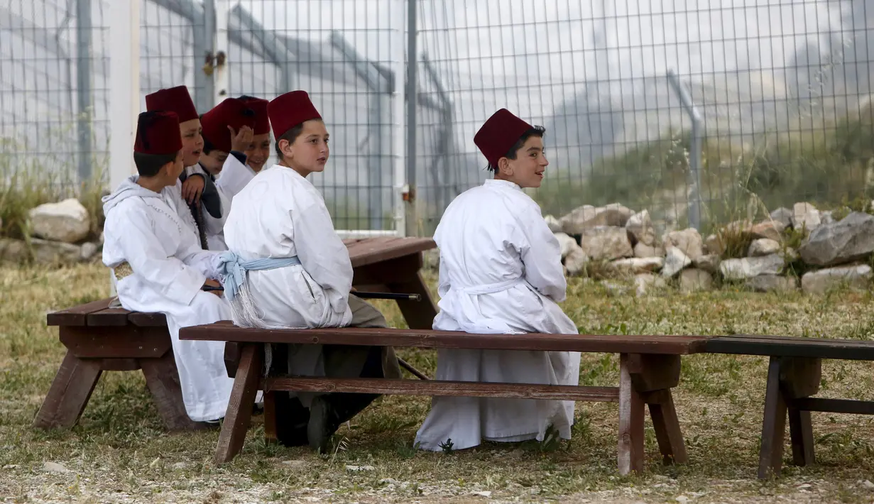 Anak-anak anggota sekte Samaritan saat melakukan kegiatan ziarah tradisional untuk menandai liburan Paskah di Gunung Gerizim, Nablus, (27/4). Komunitas agama ini telah ada sekitar 2.000 tahun yang lalu. ( REUTERS / Abed Omar Qusini)
