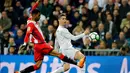 Striker Real Madrid Cristiano Ronaldo memberi umpan dan dihadang oleh pemain Girona Jonas Ramalho pertandingan La Liga Spanyol di stadion Santiago Bernabeu di Madrid (18/3). (AP Photo / Paul White)