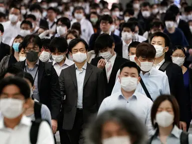 Sebuah lorong stasiun dipenuhi oleh para penumpang yang menggunakan masker selama jam sibuk di Tokyo, Selasa (26/5/2020). Perdana Menteri Jepang Shinzo Abe mencabut keadaan darurat pandemi virus corona di Tokyo dan empat wilayah lainnya pada Senin (25/5). (AP Photo/Eugene Hoshiko)