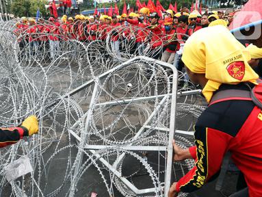 Pengunjuk rasa  menggelar demonstrasi di depan gedung DPR RI, Senayan, Jakarta, Selasa (14/3/2023). Unjuk rasa yang diikuti serikat buruh, mahasiswa, dan petani itu menuntut pemerintah untuk segera mencabut Peraturan Pemerintah Pengganti Undang-Undang (Perppu) Nomor 2 Tahun 2022 tentang Cipta Kerja. (Liputan6.com/Johan Tallo)
