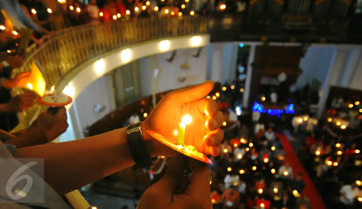 Umat Kristiani menyalakan lilin pada misa malam Natal di Gereja Immanuel, Jakarta  Sabtu (24/12). Perayaan natal berlangsung khidmat. (Liputan6.com/Angga Yuniar)