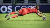 Kiper Dewa United, Sonny Stevens berusaha menangkap bola pada laga pekan ketiga BRI Liga 1 2023/2024 antara Persib Bandung melawan Dewa United di Stadion GBLA, Bandung, Jumat (14/07/2023). (Bola.com/Bagaskara Lazuardi)