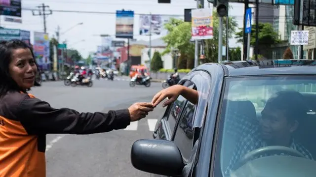 Rumiati jadi juru parkir untuk membiayai sekolah putrinya. (Merdeka.com)