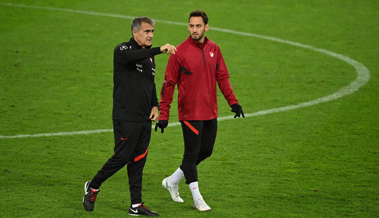 Pelatih Turki, Senol Gunes, memberikan arahan kepada Hakan Calhanoglu saat sesi latihan di Rheinenergie stadium, Jerman, Rabu (7/10/2020). Turki akan menghadapi Jerman pada laga Persahabatan. (AFP/Ina Fassbender)