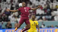 Bek Qatar, Pedro Miguel berebut bola dengan bek Ekuador, Pervis Estupinan pada pertandingan grup A Piala Dunia 2022 di Stadion Al Bayt di Al Khor, Qatar, Minggu (20/11/2022). Ekuador berhak memimpin klasemen sementara dengan koleksi tiga poin. (AP Photo/Darko Bandik)