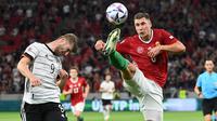 Penyerang Jerman, Timo Werner berebut bola dengan bek Hungaria, Willi Orban pada pertandingan grup A3 UEFA Nations League di Puskas Arena di Budapest, Minggu (12/6/2022). Hasil imbang ini membuat Jerman menduduki tempat ketiga klasemen grup dengan tiga poin, sedangkan Hungaria mengumpulkan empat poin. (AFP/Attila Kisbenedek)