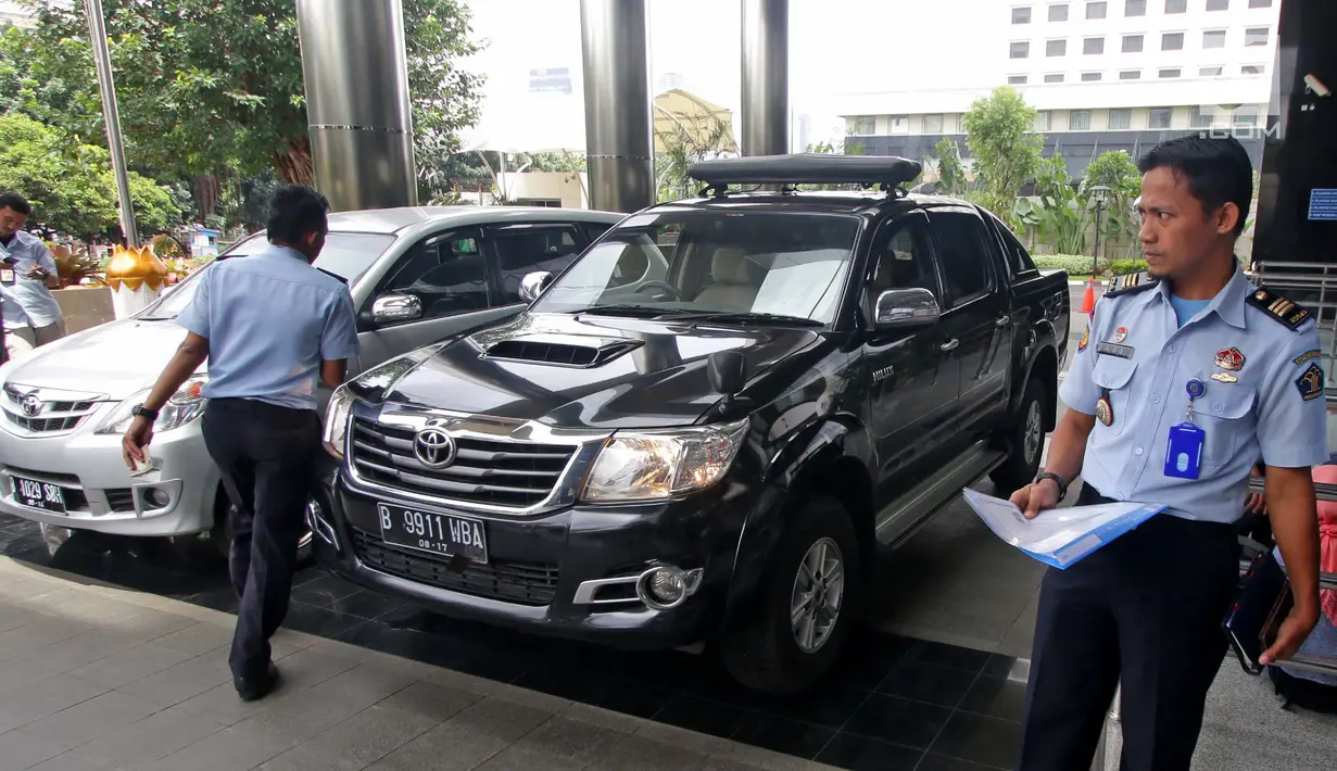 Petugas Rumah Penyimpanan Benda Sitaan Negara (Rupbasan) Jakarta Utara mengecek kondisi mobil sitaan di Gedung KPK, Jakarta, Selasa (30/1). Dalam kesempatan ini, KPK menyerahkan dua unit mobil sitaan. (Liputan6.com/Herman Zakharia)