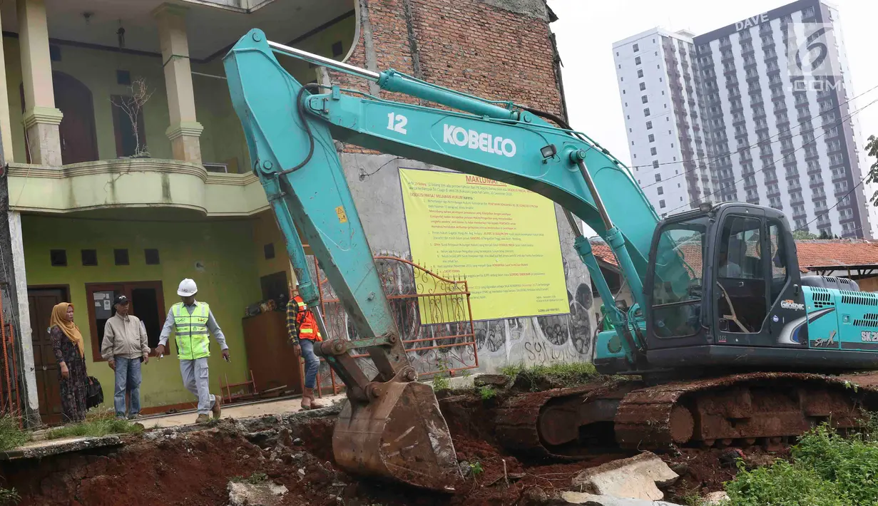 Alat berat meratakan tanah saat eksekusi lahan untuk proyek jalan Tol Cijago di kawasan Kukusan, Depok, Rabu (12/12). PN Depok kembali mengeksekusi 20 bidang lahan terkait proyek jalan tol Cijago Seksi II sepanjang 5,5 km. (Liputan6.com/Immanuel Antonius)