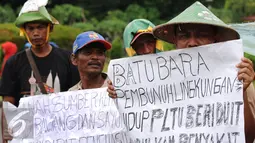 Beberapa warga mengangkat tulisan saat melakukan unjuk rasa di depan Istana Negara, Jakarta, Senin (17/1). Dalam aksinya, mereka menolak pembangunan mega proyek Pembangkit Listrik Tenaga Uap (PLTU) di Cirebon. (Liputan6.com/Helmi Fithriansyah)