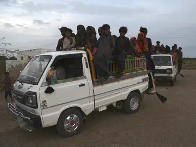 Penduduk setempat bepergian dengan kendaraan saat mereka mengevakuasi daerah tersebut karena Topan Biparjoy mendekat, di daerah pesisir Golarchi di distrik Badin, di provinsi Sindh Pakistan, Selasa, 13 Juni 2023. (AP Photo/Umair Rajput)