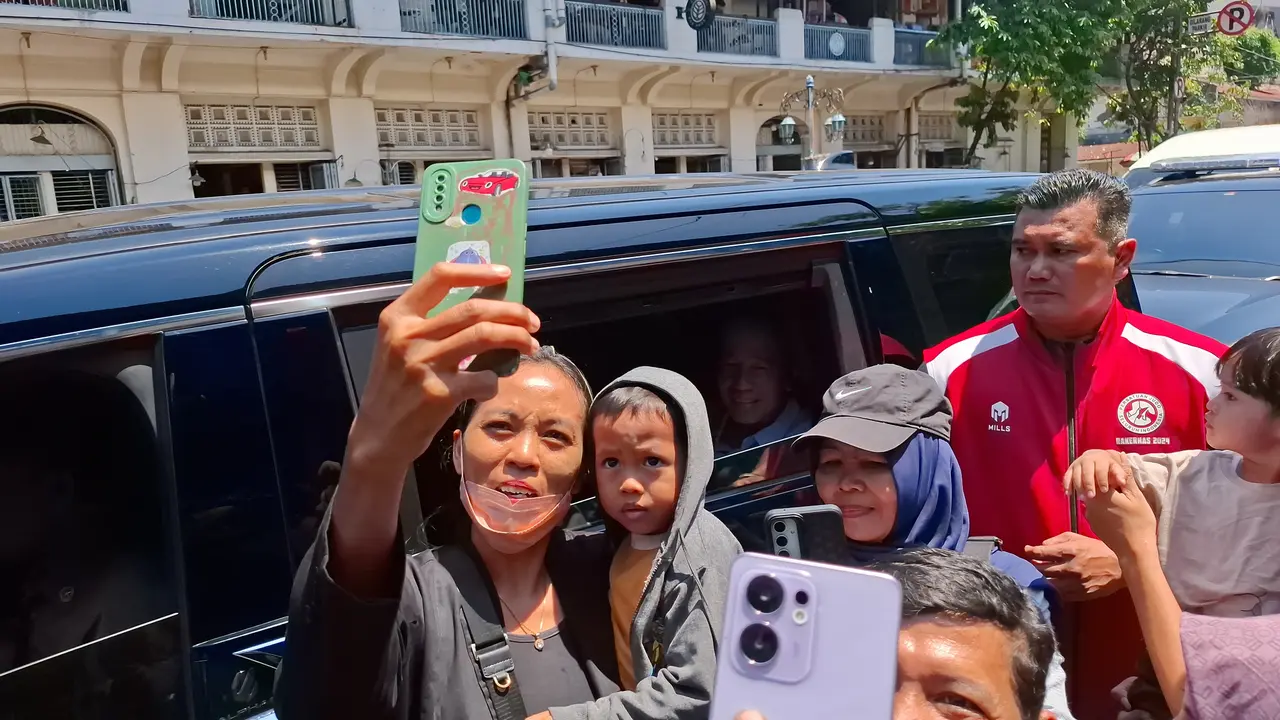 Warga mengajak Presiden ke-7 RI Joko Widodo atau Jokowi untuk berswafoto saat momen membagikan paket sembako di Solo.