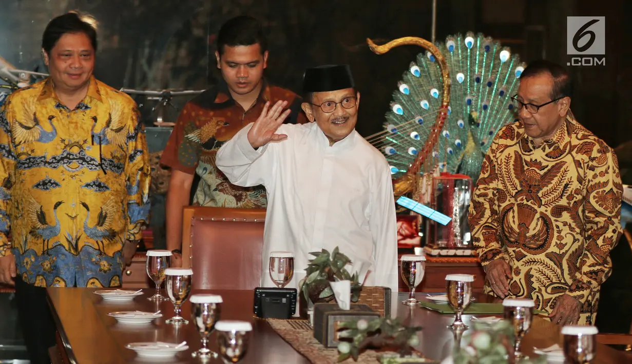 Ketua Dewan Kehormatan Partai Golkar BJ Habibie (tengah) melambaikan tangan ke arah wartawan saat menerima silaturahmi Ketua Umum Partai Golkar Airlangga Hartarto (kiri) di kediamannya, Jakarta, Jumat (3/8). (Liputan6.com/JohanTallo)