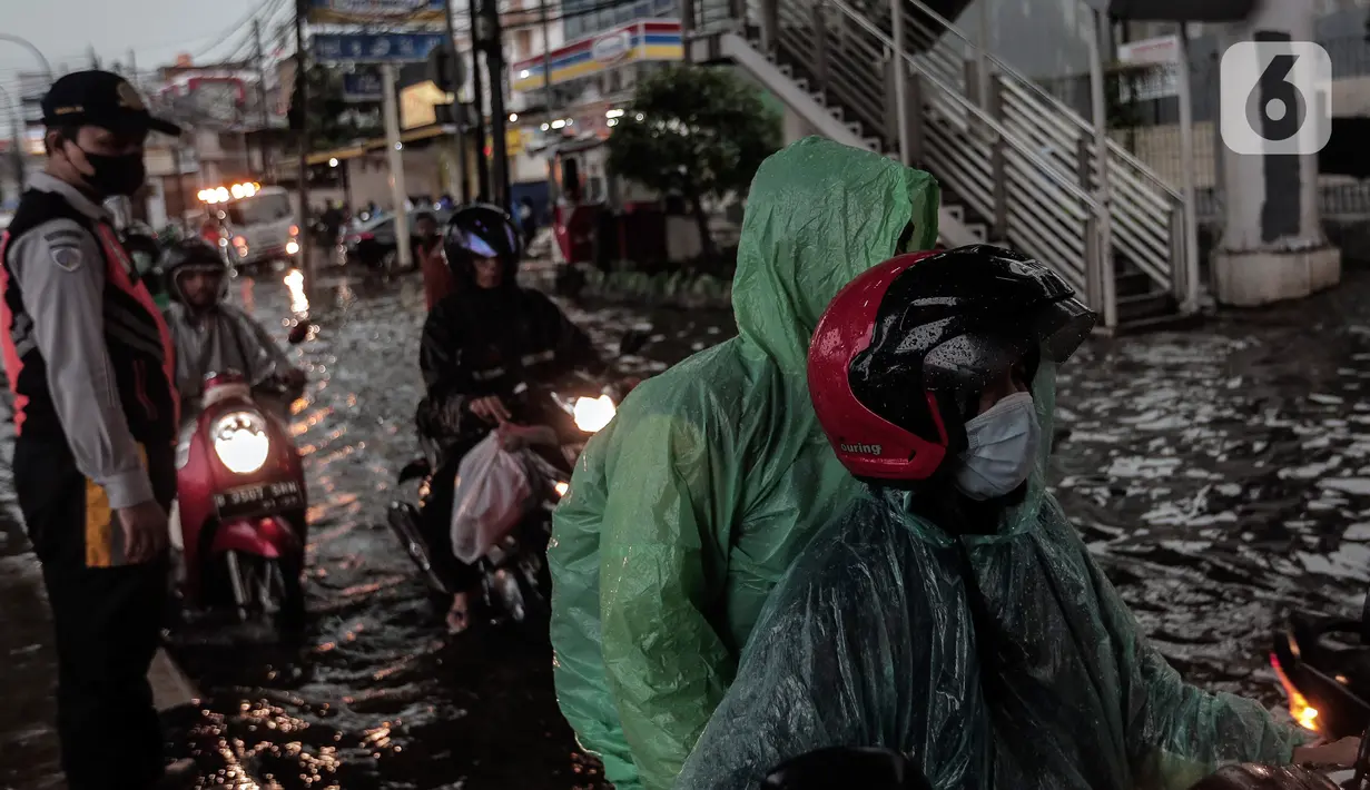 Petugas mengatur lalu lintas saat banjir menggenangi kawasan Seskoal - Cipulir, Jakarta, Selasa (4/4/2022). Hujan yang mengguyur wilayah Ibu Kota Jakarta mengakibatkan banjir menggenangi kawasan Simpang Seskoal, Kebayoran Lama, Jakarta. Banjir setinggi 50cm - 1 meter disebabkan saluran pembuangan berukuran kecil tersumbat. (Liputan6.com/Johan Tallo)