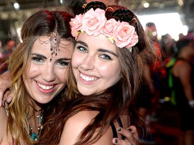  Senyum manis dua wanita saat menghadiri hari pertama Coachella Valley Music and Arts Festival 2016 di Empire Polo Club, Indio, California (15/4). Festival Coachella ini sudah ada sejak 1999. (AFP/Michael Tullberg)