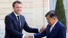 Presiden Prancis Emmanuel Macron (kiri) menyalami Wakil Presiden Indonesia Jusuf Kalla saat menghadiri KTT Paris: Ekstremisme Online di Istana Elysee, Paris, Prancis, Rabu (15/5/2019). Presiden Macron terlihat hangat saat menyambut Wapres Kalla. (REUTERS/Philippe Wojazer)