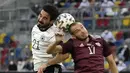 Gelandang Jerman, Ilkay Gundogan (kiri) berduel udara dengan gelandang Latvia, Arturs Zjuzins dalam laga uji coba menjelang Euro 2020 (Euro 2021) di Merkur Spiel Arena, Duesseldorf, Senin (7/6/2021). Jerman menang 7-1 atas Latvia. (AP/Martin Meissner)