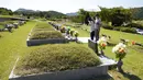 Anggota keluarga memberi penghormatan kepada pemakaman leluhur mereka menjelang liburan Chuseok di sebuah pemakaman di Paju, Korea Selatan (12/9/2021).  Pemakaman nasional Korea Selatan akan ditutup selama liburan Chuseok. (AP Photo/Ahn Young-joon)