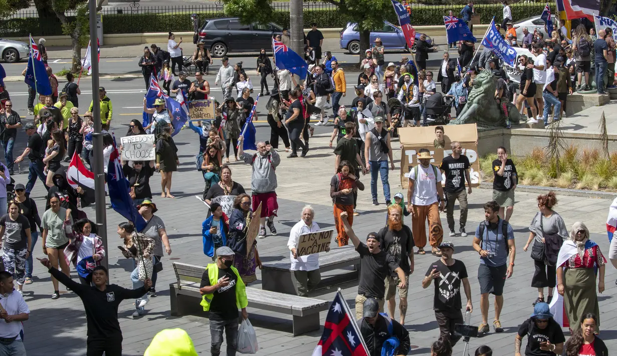 Pengunjuk rasa berbaris di sepanjang Lambton Quay sebelum berkumpul di gedung Parlemen Selandia Baru, di Wellington, Selasa (9/11/2021). Ribuan warga Selandia Baru berdemonstrasi memprotes kebijakan vaksin covid-19 dan penguncian (lockdown) yang diterapkan negara itu (Mark Mitchell/NZ Herald via AP)