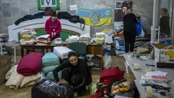 Kesibukan relawan Ukraina saat menyortir pakaian yang disumbangkan untuk kemudian didistribusikan ke penduduk setempat di Lviv, Ukraina barat, pada Rabu (2/3/2022). Invasi Rusia ke Ukraina telah memasuki hari keenam. (AP Photo/Bernat Armangue)