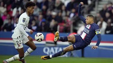 Penyerang Paris Saint-Germain (PSG) Kylian Mbappe menendang bola di sebelah bek Rennes, Warmed Omari pada  Ligue 1 2022/2023 pekan ke-28 di Parc des Princess, Senin (20/3/2023). (AP Photo/Christophe Ena)