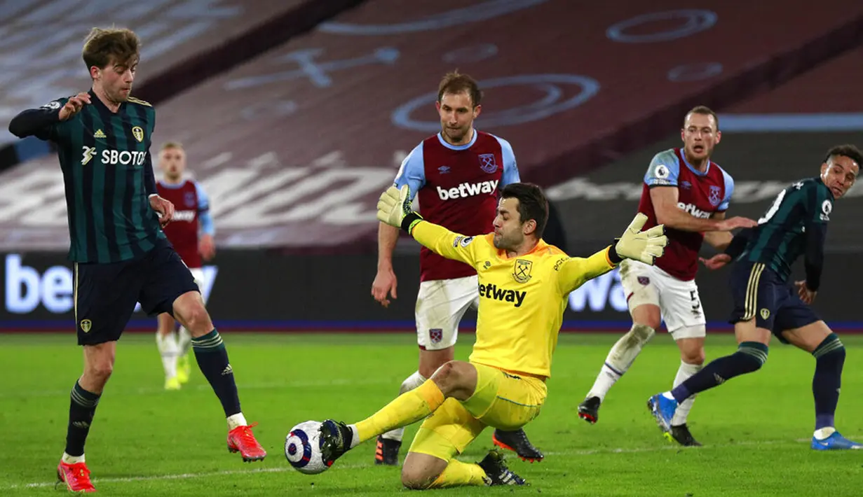 Penjaga gawang West Ham United Lukasz Fabianski (tengah) melakukan penyelamatan di depan pemain Leeds United Patrick Bamford pada pertandingan Liga Inggris di Stadion London, London, Inggris, Senin (8/3/2021). West Ham United menang 2-0. (Ian Walton, Pool)
