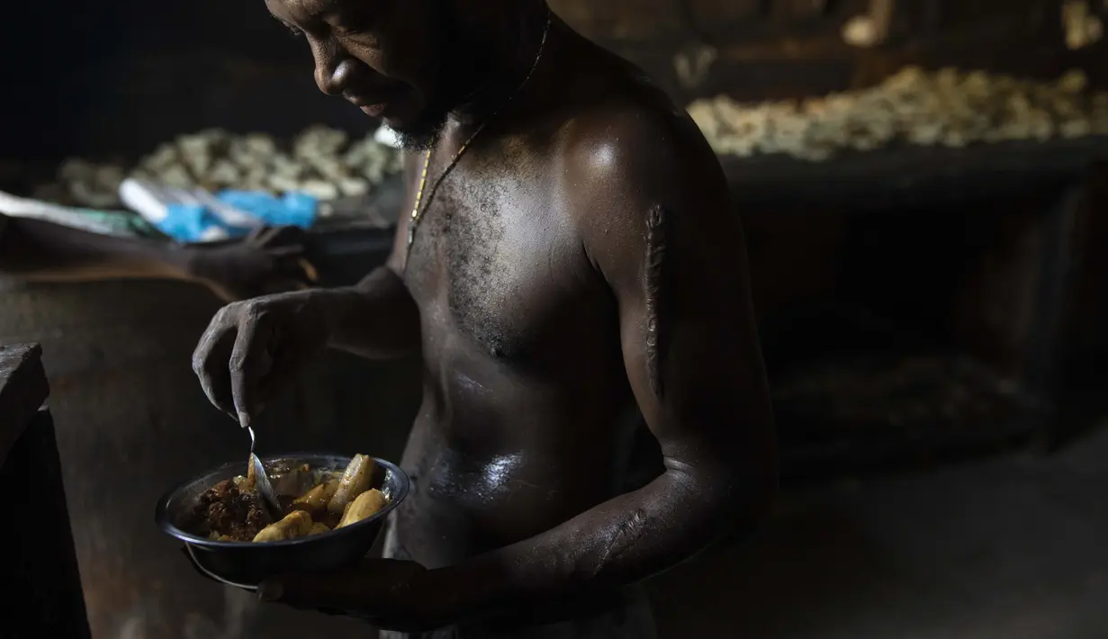 Saint Jean Renel (42) makan siang sambil istirahat dari membuat roti di dalam toko roti Bongu di lingkungan Bel Air Port-au-Prince, Haiti, Senin (27/9/2021).  (AP Photo/Rodrigo Abd)