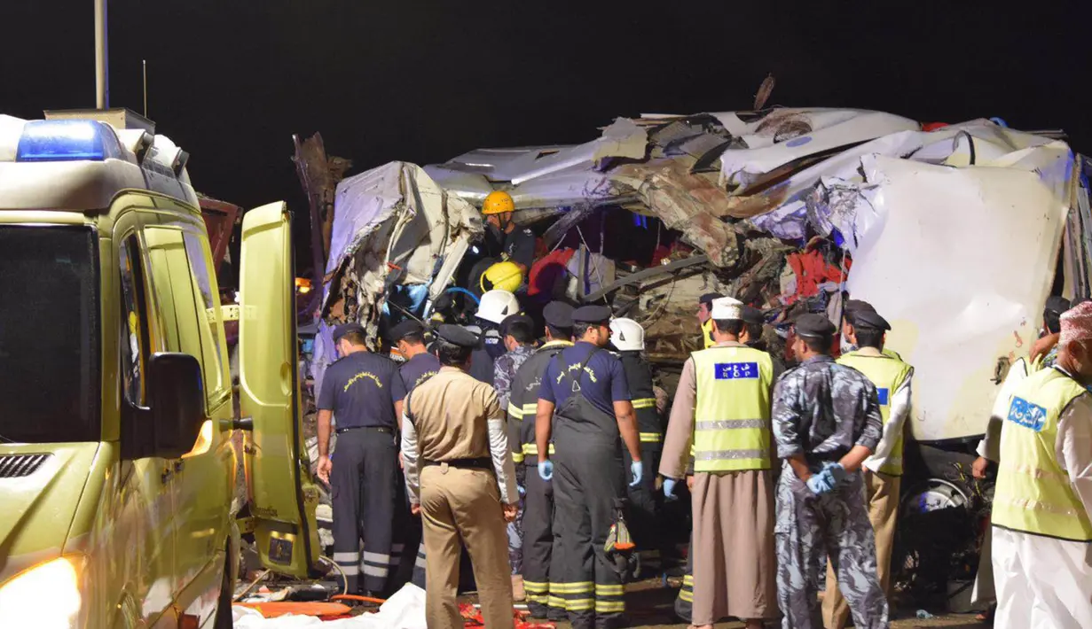 Petugas memeriksa bangkai bus yang kecelakaan akibat menabrak sebuah truk di jalan raya antara Ibri dan Fahud, Oman bagian barat, Selasa (1/3). Sebanyak 18 orang dari beberapa kewarganegaraan tewas dan 14 lainnya luka-luka. (STRINGER/Omani Police/AFP) 