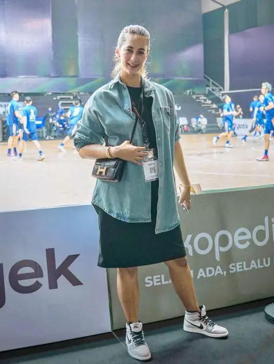 Kali ini, Paula tampil kece memadukan mini dress berwarna hitam dengan kemeja denim lengan panjang dan sneakers Nike Air Jordan 1 Retro High plus mini sling bag Hermes warna hitam. (Instagram/paula_verhoeven).