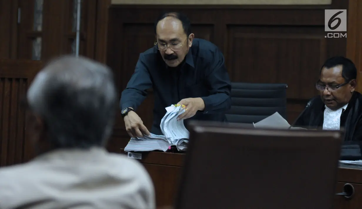 Terdakwa kasus dugaan merintangi penyidikan korupsi e-KTP, Fredrich Yunadi (tengah) membuka berkas pada sidang lanjutan di Pengadilan Tipikor, Jakarta, Kamis (26/4). Sidang mendengar keterangan saksi. (Liputan6.com/Helmi Fithriansyah)
