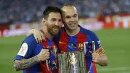 Pemain Barcelona Lionel Messi dan Andres Iniesta mengangkat trofi Piala Raja Spanyol (Copa del Rey) di stadion Vicente Calderon, Spanyol, Minggu (28/5). Barca mengalahkan Alaves 3-1 di laga final tersebut. (AP Photo)