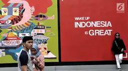 Pengunjung  berpose  di depan mural karya seniman Yogyakarta yang bertajuk INDONESIA IS GREAT, Jakarta, Sabtu (22/7). Pameran ini dalam rangka mewadahi para seniman mural dalam menyuarakan kritik positif maupun negatif. (Liputan6.com/Helmi Afandi)