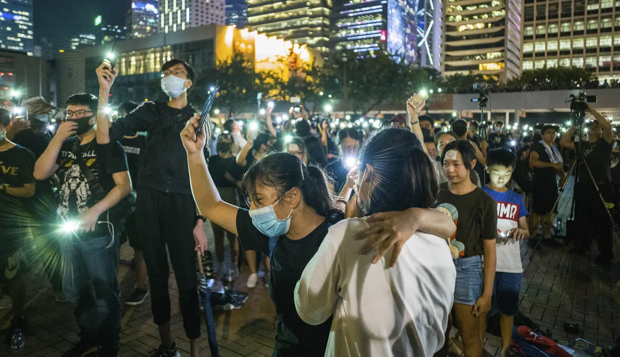 Mahasiswa menyanyikan 'Do You Hear the People Sing' dari 'Les Miserables' selama rapat umum di Hong Kong (22/8/2019). Mahasiswa mengancam bertindak lebih jauh jika pemerintah tidak memenuhi lima tuntutan demonstran, termasuk mencabut RUU Ekstradisi. (AFP Photo/Anthony Wallace)