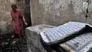 Warga mencari sisa barang di antara puing bangunan rumah yang hangus akibat kebakaran di Tambora, Jakarta, Kamis (10/1). Seminggu pascakebakaran, para korban masih bertahan di rumahnya meski dengan kondisi memprihatinkan. (Merdeka.com/Iqbal Nugroho)