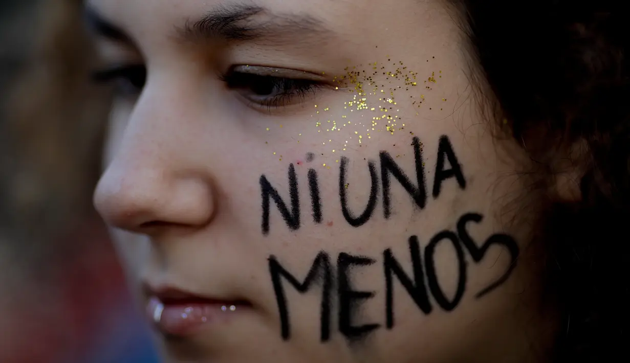 Seorang wanita ikut dalam demonstrasi menentang kekerasan gender di Buenos Aires, Argentina, Sabtu (3/6). Demonstran membawa hashtag #NiUnaMenos, yang berarti "tidak sedikit". (Foto AP / Natacha Pisarenko)