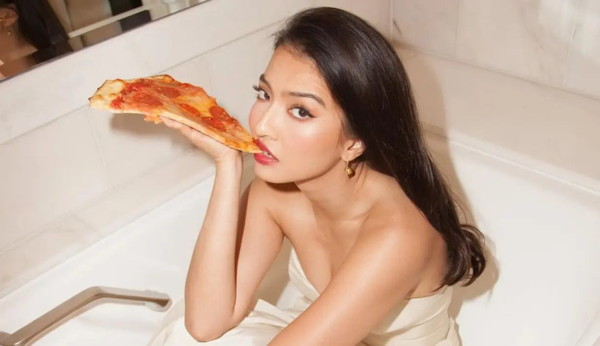 Kali ini, bintang film 5 CM ini kembali tampil dalam sebuah pemotretan. Uniknya, pemotretan ini dilakukan di dalam bathub yang terlihat kering. Selain itu, Raline pun nampak sedang memegangi satu potong pizza di tangannya. (Liputan6.com/IG/ralineshah)