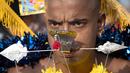 Seorang pria menusuk pipinya dengan batang logam saat Festival Thaipusam di Gua Batu, Kuala Lumpur, Malaysia, Senin (21/1). Prosesi tahunan ini dirayakan oleh umat Hindu di seluruh dunia untuk menghormati Dewa Murugan. (AP Photo/ Vincent Thian)