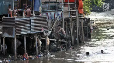 Anak-anak berenang di bawah jamban yang berada di bantaran Kali Ciliwung, Jakarta, Senin (19/11). Saat ini, tercatat sekitar 500 ribu penduduk DKI Jakarta tidak memiliki akses sanitasi yang layak. (Merdeka.com/Iqbal Nugroho)