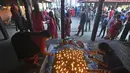 Seorang umat Hindu melakukan ritual dengan berbaring di tempat tidur yang ditutupi dengan 108 lampu minyak menyala pada hari kesepuluh festival Dashain di sebuah kuil di Bhaktapur di pinggiran Kathmandu (15/10/2021). (AFP/Prakash Matematika)