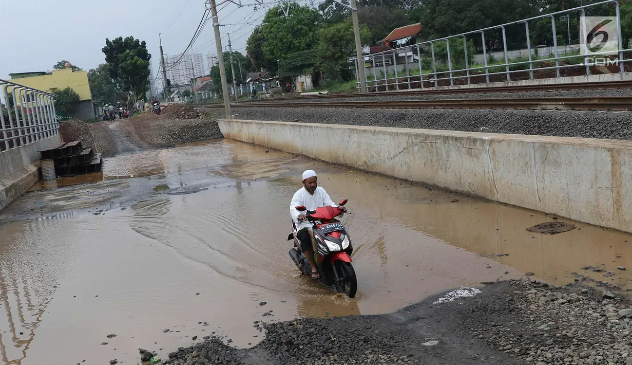 Pengendara motor melintasi genangan air di kawasan Kemiri Muka, Depok, Jawa Barat, Senin (2/10). Buruknya sistem drainase menyebabkan air selalu menggenang setiap musim hujan sehingga mengganggu aktivitas warga. (Liputan6.com/Immanuel Antonius)