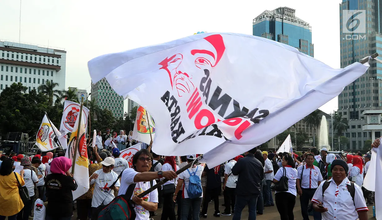 Ratusan relawan Jokowi Poros Benhil melakukan aksi damai salam jempol ceria di kawasan Monas, Jakarta, Jumat (11/1). Aksi tersebut sebagai  bentuk pesan ceria kepada masyarakat. (Liputan6.com/Johan Tallo)